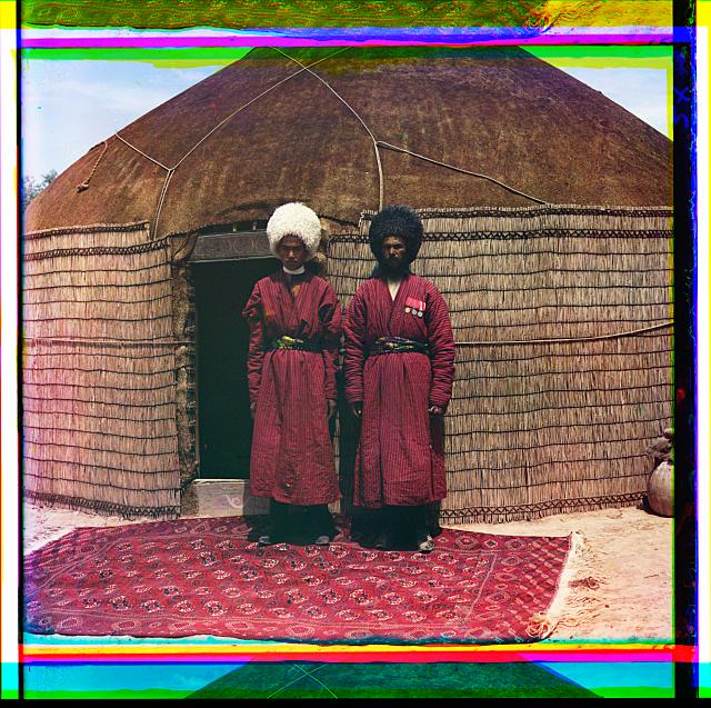 Two men standing on a rug, in front of yurt